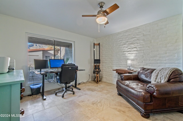 home office featuring ceiling fan and brick wall