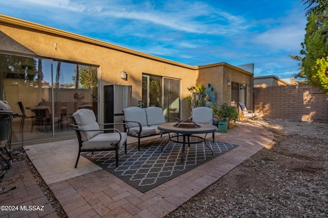 view of patio with an outdoor living space with a fire pit