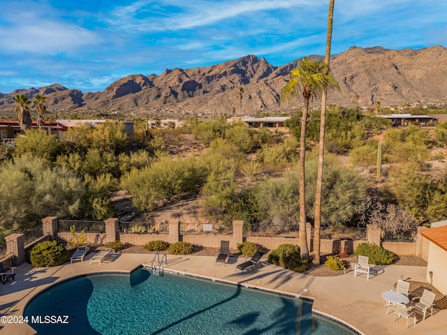 view of swimming pool with a mountain view and a patio