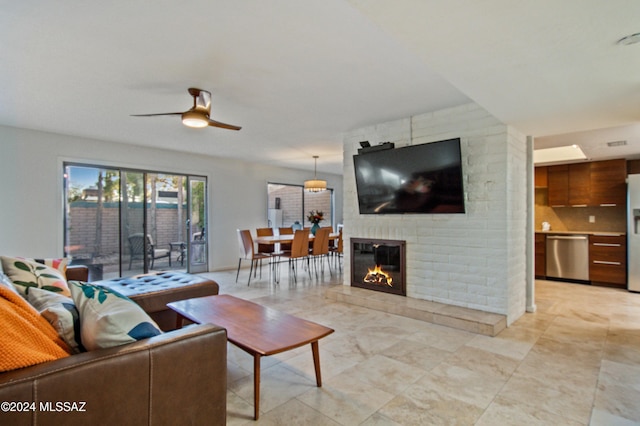 living room with ceiling fan and a brick fireplace