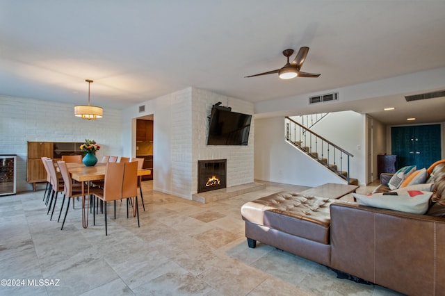 living room featuring wine cooler, a fireplace, and ceiling fan