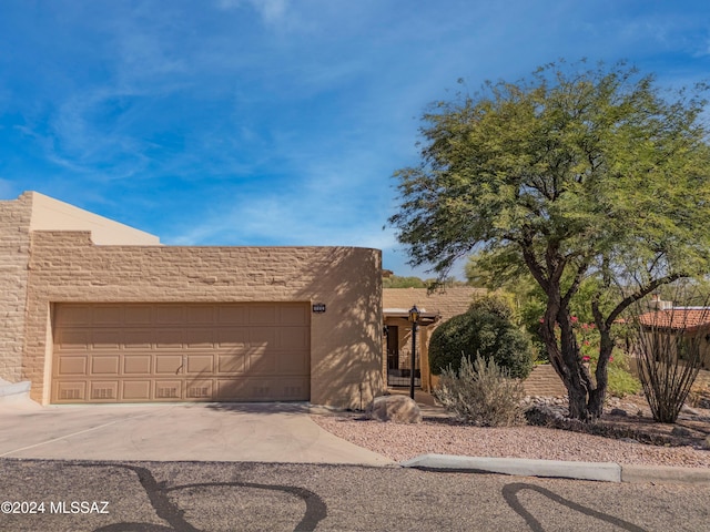 pueblo-style house featuring a garage