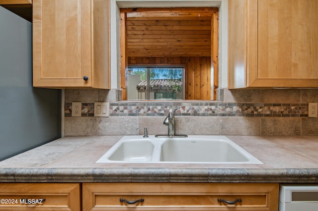 kitchen with tile countertops, decorative backsplash, and sink