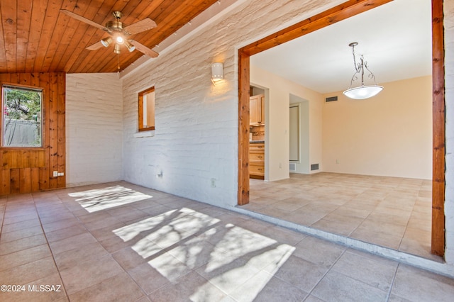 unfurnished room featuring lofted ceiling, wooden walls, ceiling fan, and wooden ceiling