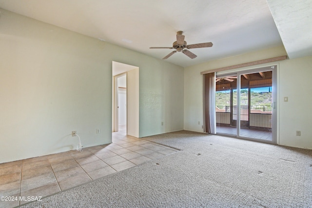 carpeted spare room featuring ceiling fan