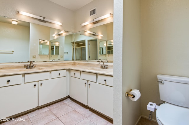 bathroom featuring tile patterned floors, vanity, toilet, and a shower with shower door