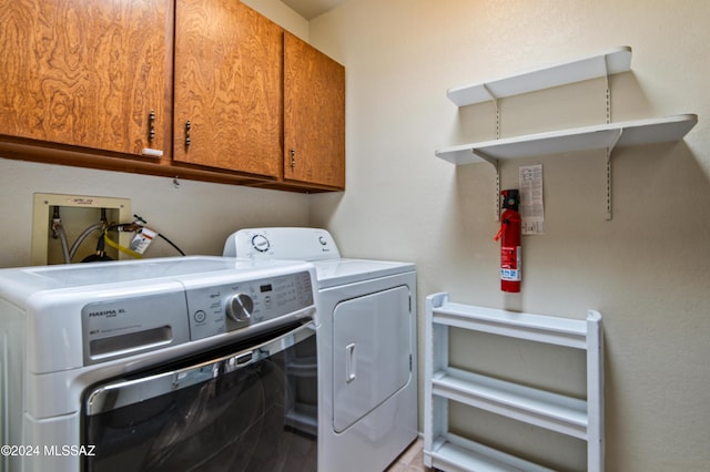 laundry room with separate washer and dryer and cabinets