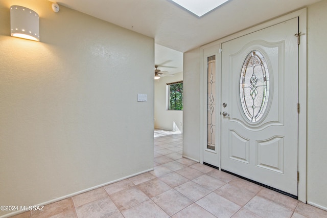 tiled foyer featuring ceiling fan