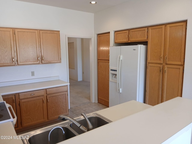 kitchen with sink, white refrigerator with ice dispenser, and range