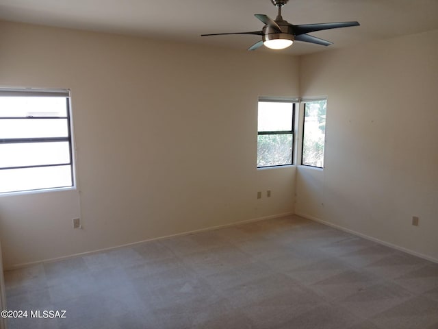 carpeted spare room featuring ceiling fan