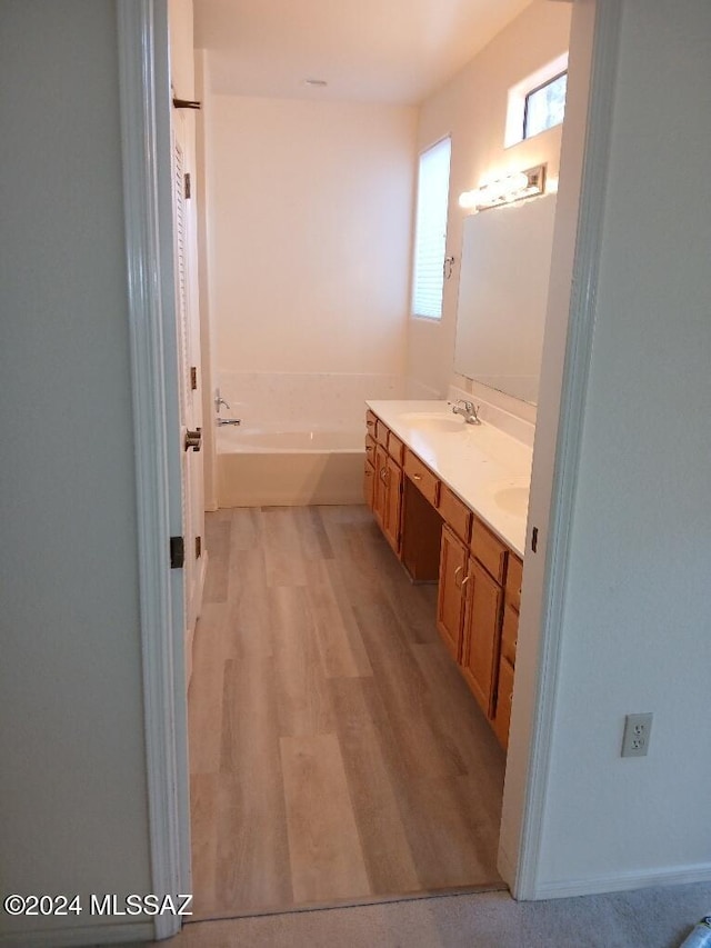 bathroom featuring vanity, hardwood / wood-style flooring, and a bathing tub