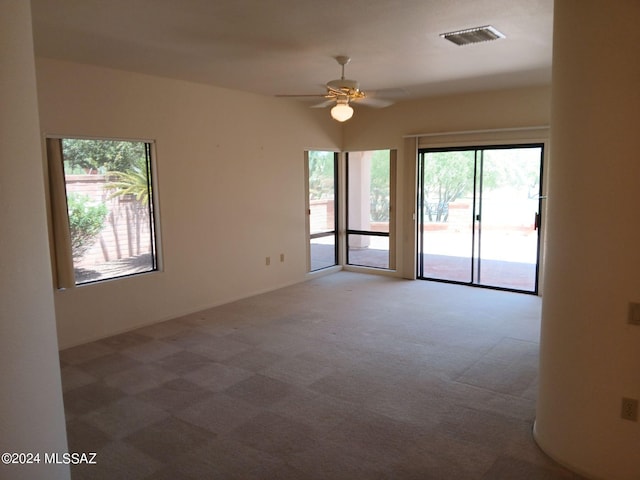 carpeted spare room with ceiling fan