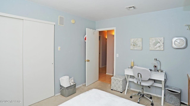 bedroom featuring light carpet and a closet