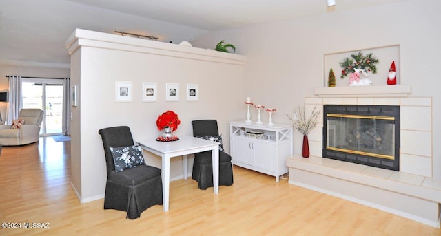 living area featuring a fireplace, lofted ceiling, and light wood-type flooring