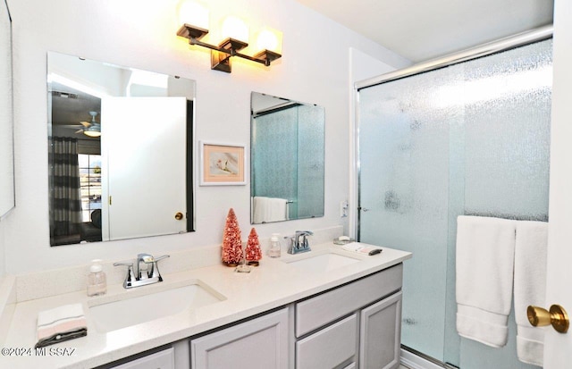 bathroom with ceiling fan, a shower with door, and vanity