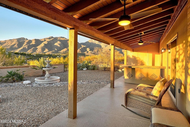 view of patio / terrace with ceiling fan and a mountain view