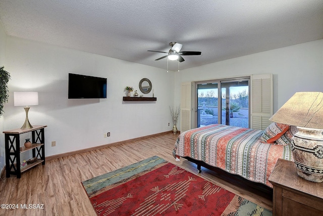 bedroom featuring hardwood / wood-style flooring, ceiling fan, a textured ceiling, and access to outside