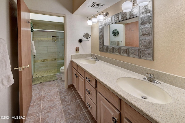 bathroom featuring vanity, a shower with shower door, tile patterned floors, and toilet