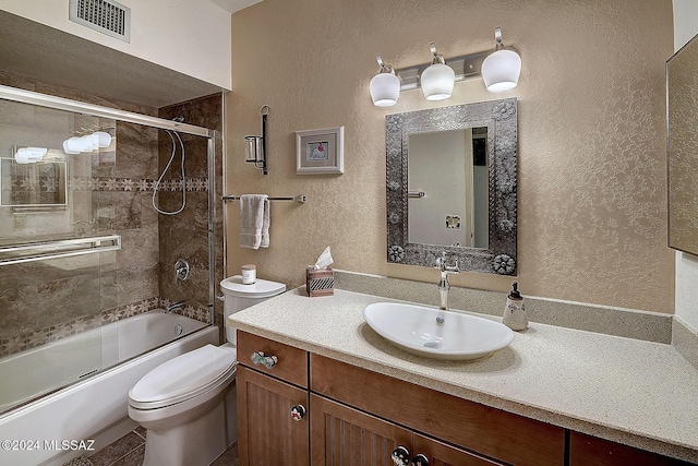 full bathroom featuring vanity, bath / shower combo with glass door, and toilet