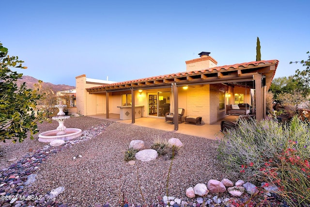 back of house featuring a mountain view and a patio