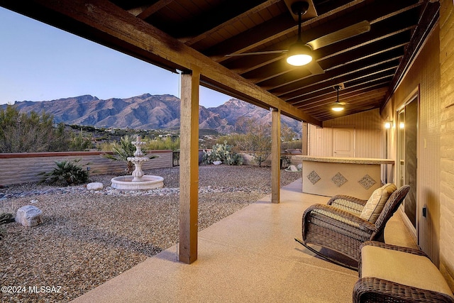 patio terrace at dusk featuring a mountain view