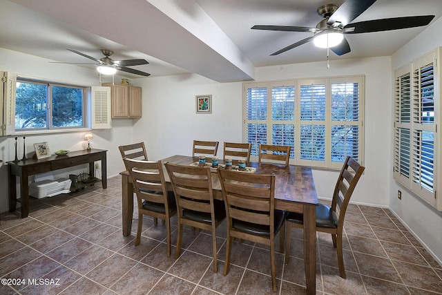 dining room featuring dark tile patterned floors and ceiling fan