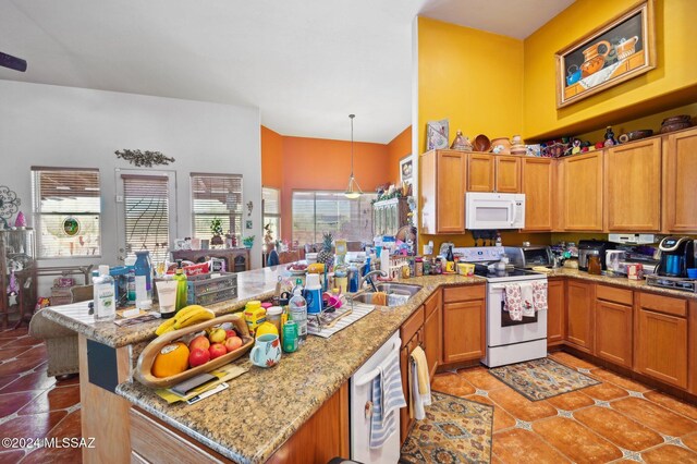 kitchen with plenty of natural light, hanging light fixtures, white appliances, and sink