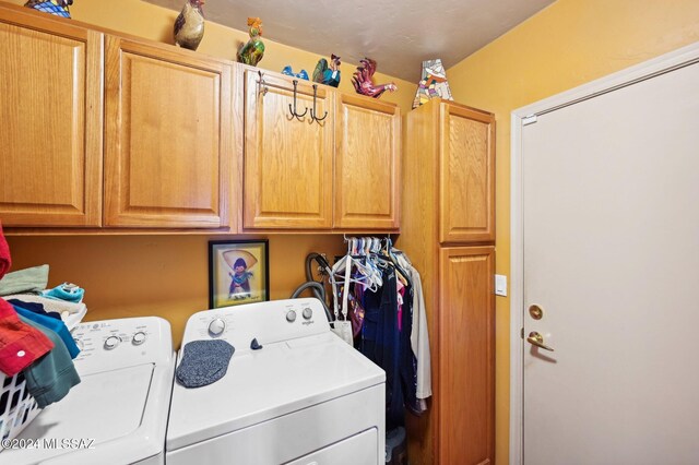 laundry room featuring washer and dryer and cabinets