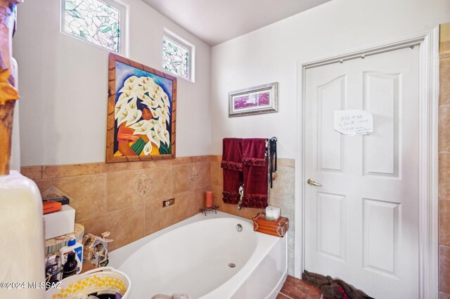 bathroom with a bath and tile walls