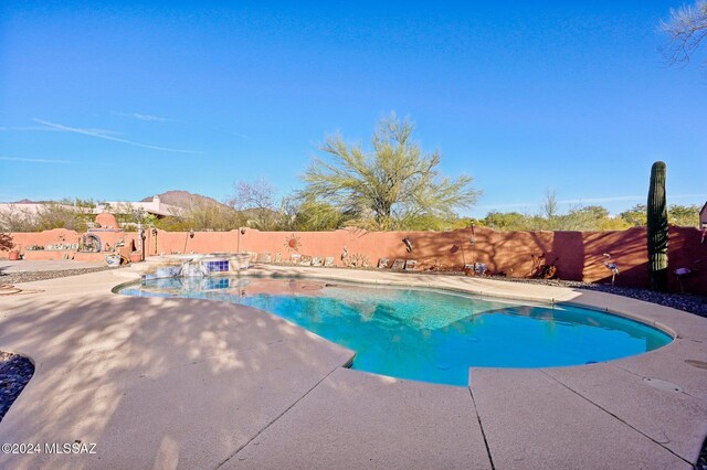 view of swimming pool with a mountain view and a patio