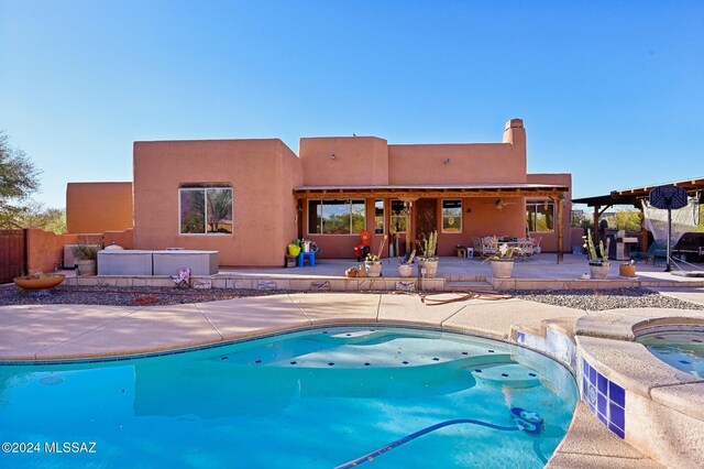 view of swimming pool with a patio area and an in ground hot tub