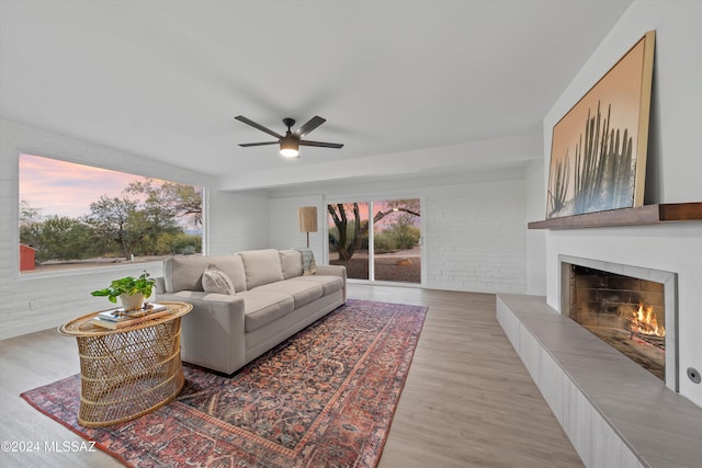 living room with ceiling fan, plenty of natural light, and light hardwood / wood-style floors