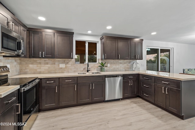 kitchen featuring sink, stainless steel appliances, dark brown cabinets, and light hardwood / wood-style flooring