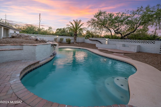 pool at dusk with a patio