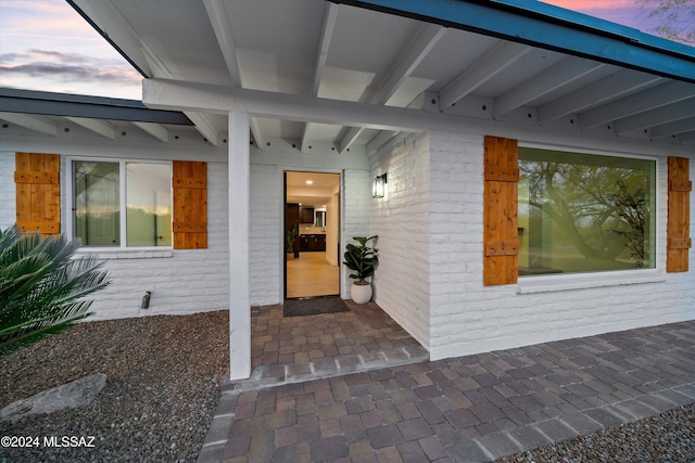 exterior entry at dusk featuring a patio