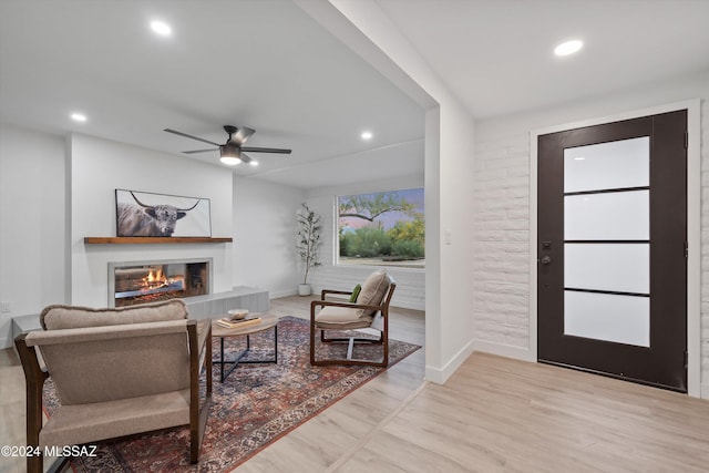 entrance foyer with a fireplace, light hardwood / wood-style flooring, and ceiling fan