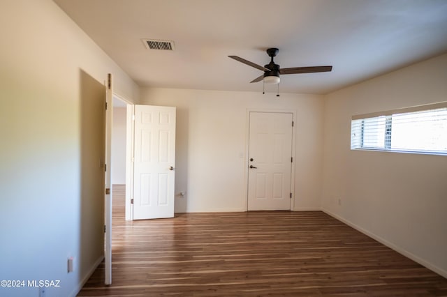 unfurnished room with ceiling fan and dark wood-type flooring