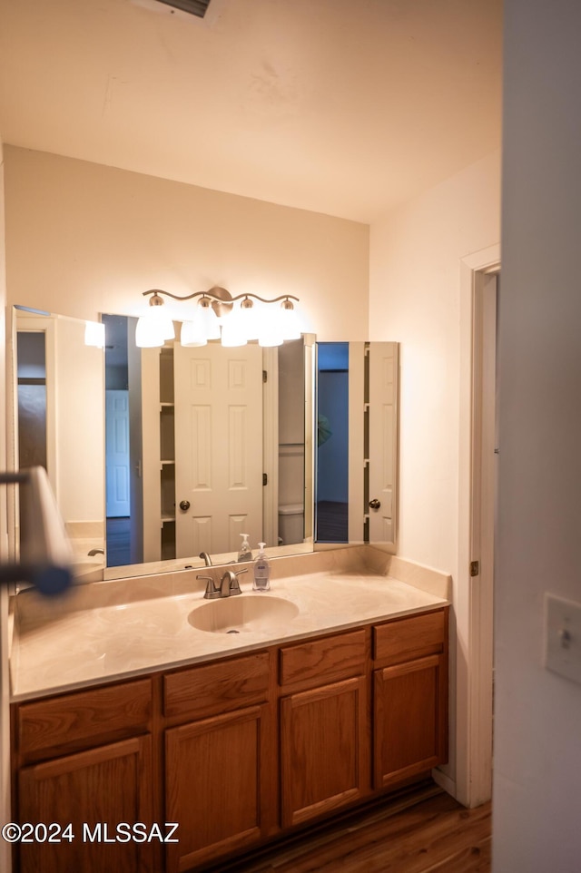 bathroom with vanity, toilet, and wood-type flooring