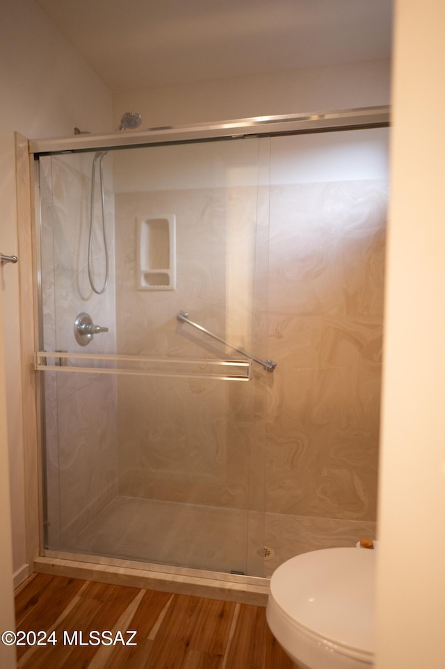 bathroom featuring hardwood / wood-style flooring, toilet, and an enclosed shower