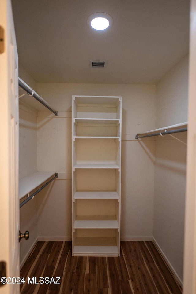 spacious closet featuring dark hardwood / wood-style flooring