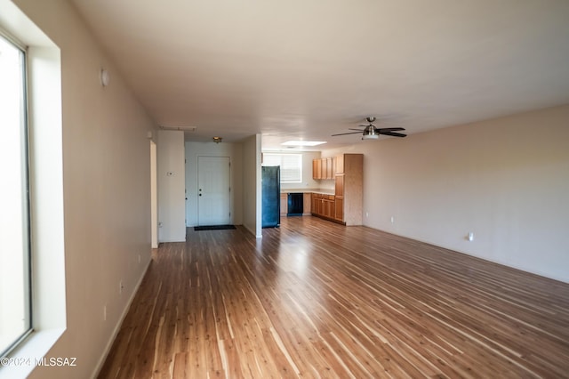 unfurnished living room with a wealth of natural light, ceiling fan, and hardwood / wood-style flooring