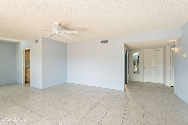 tiled spare room featuring ceiling fan and a textured ceiling