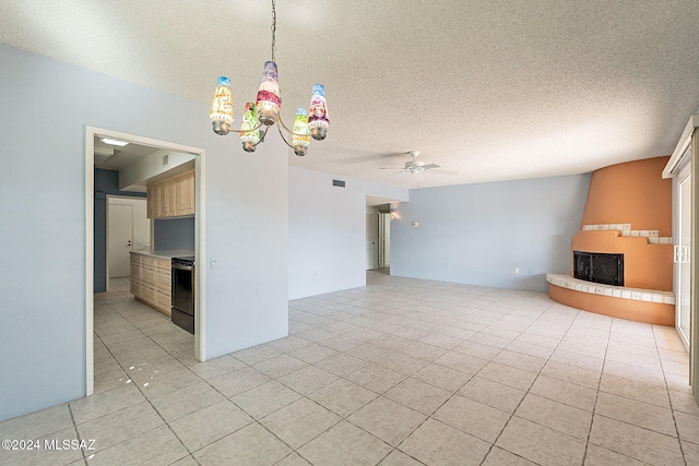 unfurnished living room with light tile patterned floors, ceiling fan with notable chandelier, and a textured ceiling