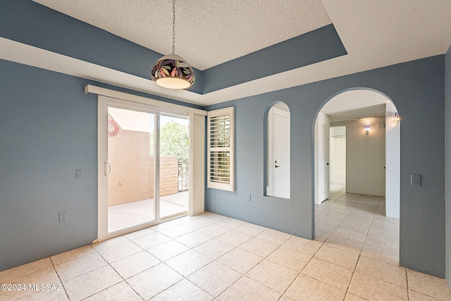 tiled spare room with a textured ceiling