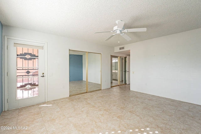 empty room featuring ceiling fan and a textured ceiling