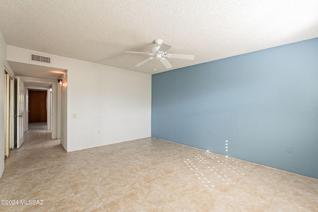 spare room with ceiling fan and a textured ceiling