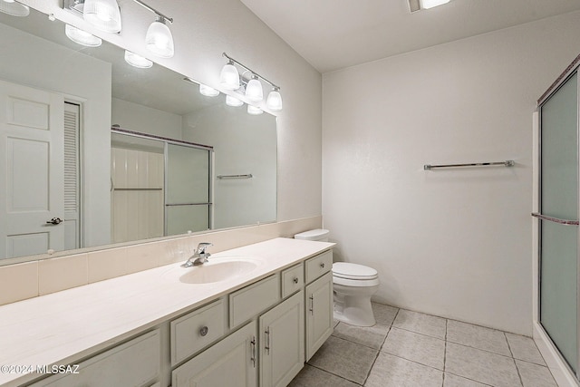 bathroom with toilet, vanity, tile patterned floors, and walk in shower