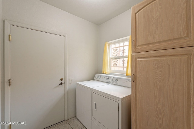 laundry room with independent washer and dryer and light tile patterned floors