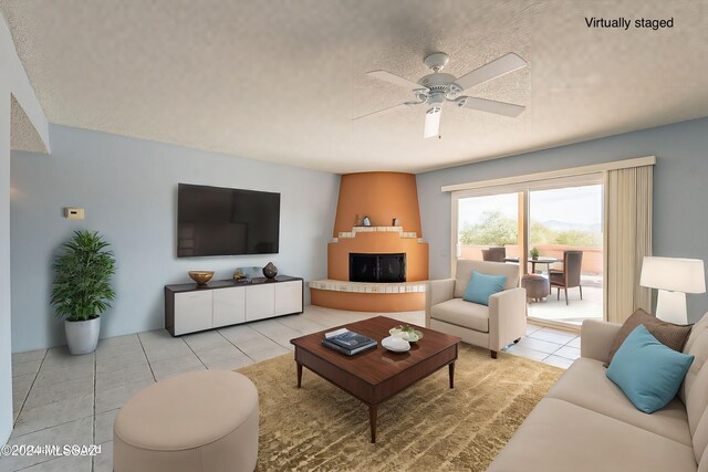 living room featuring light tile patterned floors, a textured ceiling, and ceiling fan