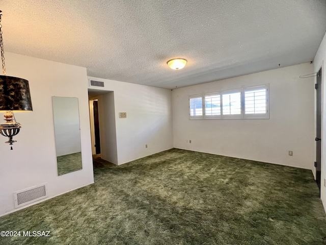 carpeted empty room with a textured ceiling